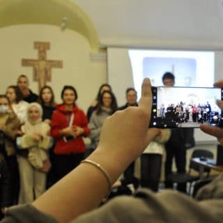 Na pierwszym planie widoczyny ekran telefonu podczas robienia zdjęcia grupowego uczestnikom warsztatów