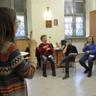 Uczestnicy kursu IS siedzą w sali w półkolu wokół lektorki prowadzącej zajęcia