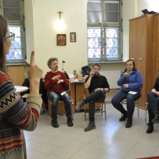 Uczestnicy kursu IS siedzą w sali w półkolu wokół lektorki prowadzącej zajęcia