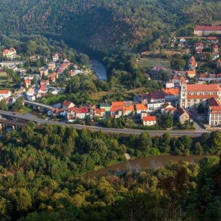 Zdjęcie Barda Śląskiego z lotu ptaka, obok zabudowań widoczna rzeka i lasy