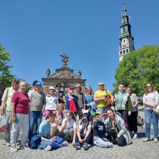 Zdjęcie grupowe uczestników pielgrzymki, w tle wieża kościoła na Jasnej Górze