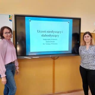 Dwie kobiety przy monitorze z napisem Uczeń niesłyszący i słabosłyszący
