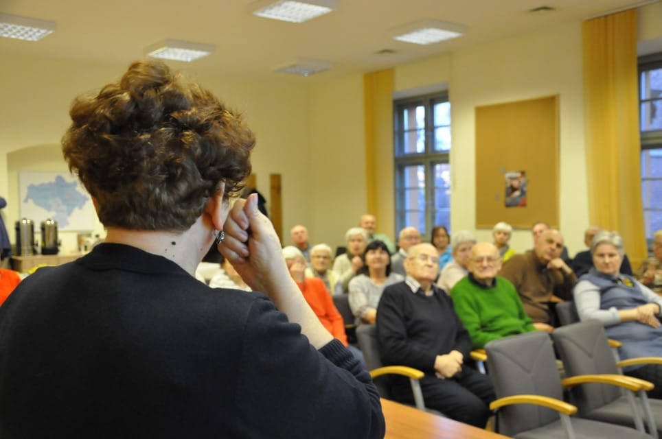 Otyłość i niedożywienie – przyczyny i skutki1 Migająca kobieta, przed nią grupa seniorów siedzi w kilku rzędach