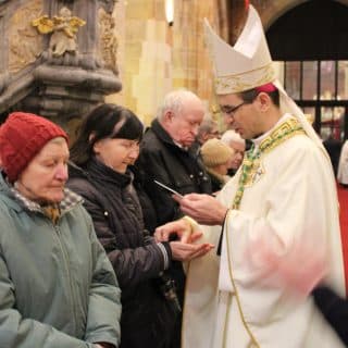W kościele biskup namaszcza dłonie kobiety
