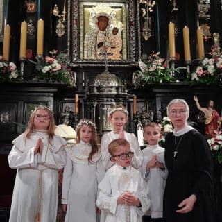Siostra zakonna z pięciorgiem dzieci komunijnych w kaplicy przy obrazie Matki Bożej Częstochowskiej