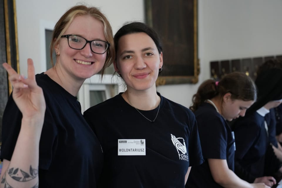 Wolontariat Fundacja FONIS Dwie uśmiechnięte młode kobiety w koszulkach Fundacji FONIS