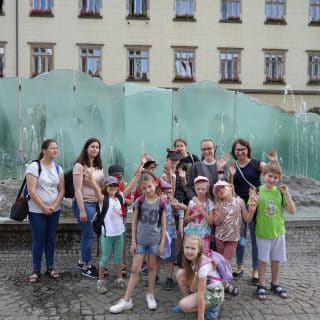 Grupa dzieci z wychowawcami na tle fontanny na wrocławskim rynku
