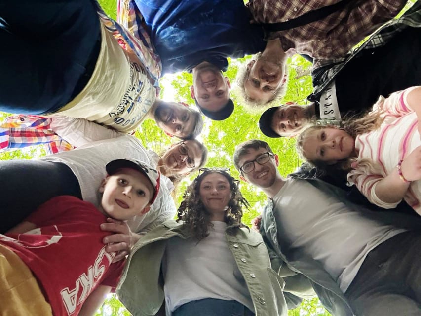 Wolontariusze w arboretum 2 Kilka osób w okręgu nachyla się trzymając się za ramiona