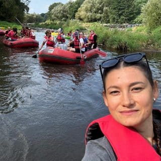 Młoda dziewczyna na tle dwóch pontonów płynących rzeką