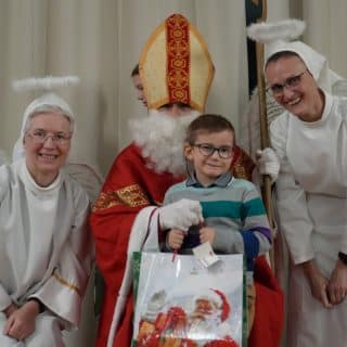 Mikołaj z chłopcem między dwoma aniołami